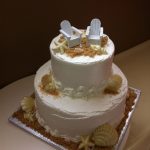 2 tier wedding cake with seashells and beach chairs
