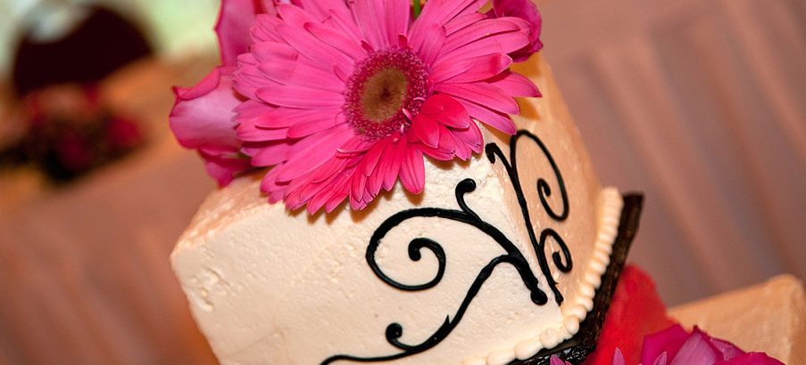 pink flower on top wedding cake