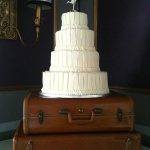 white wedding cake on suitcases