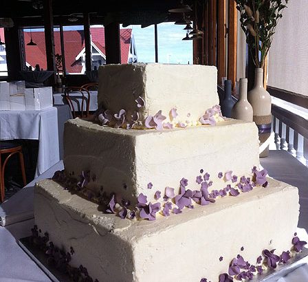 purple icing flowers on wedding cake